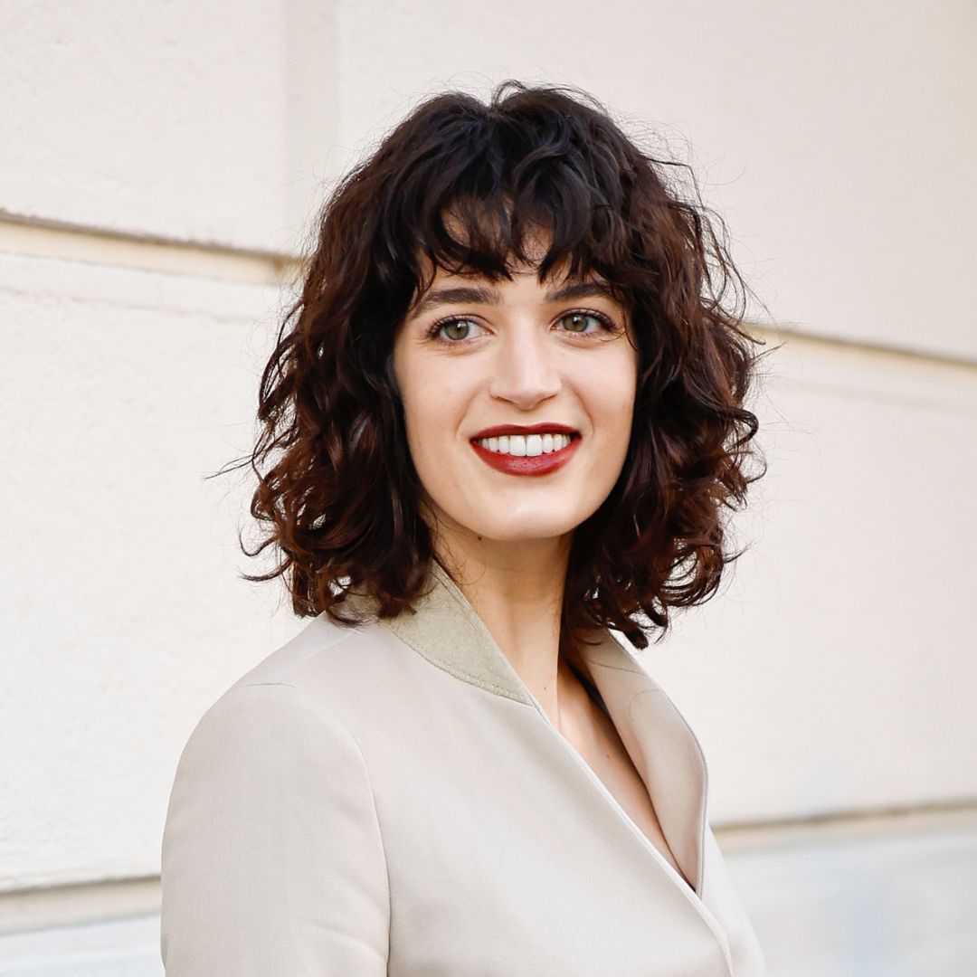 Greta Ferro wears beige blazer and perfectly styled curly hair - olaplex no.10 review
