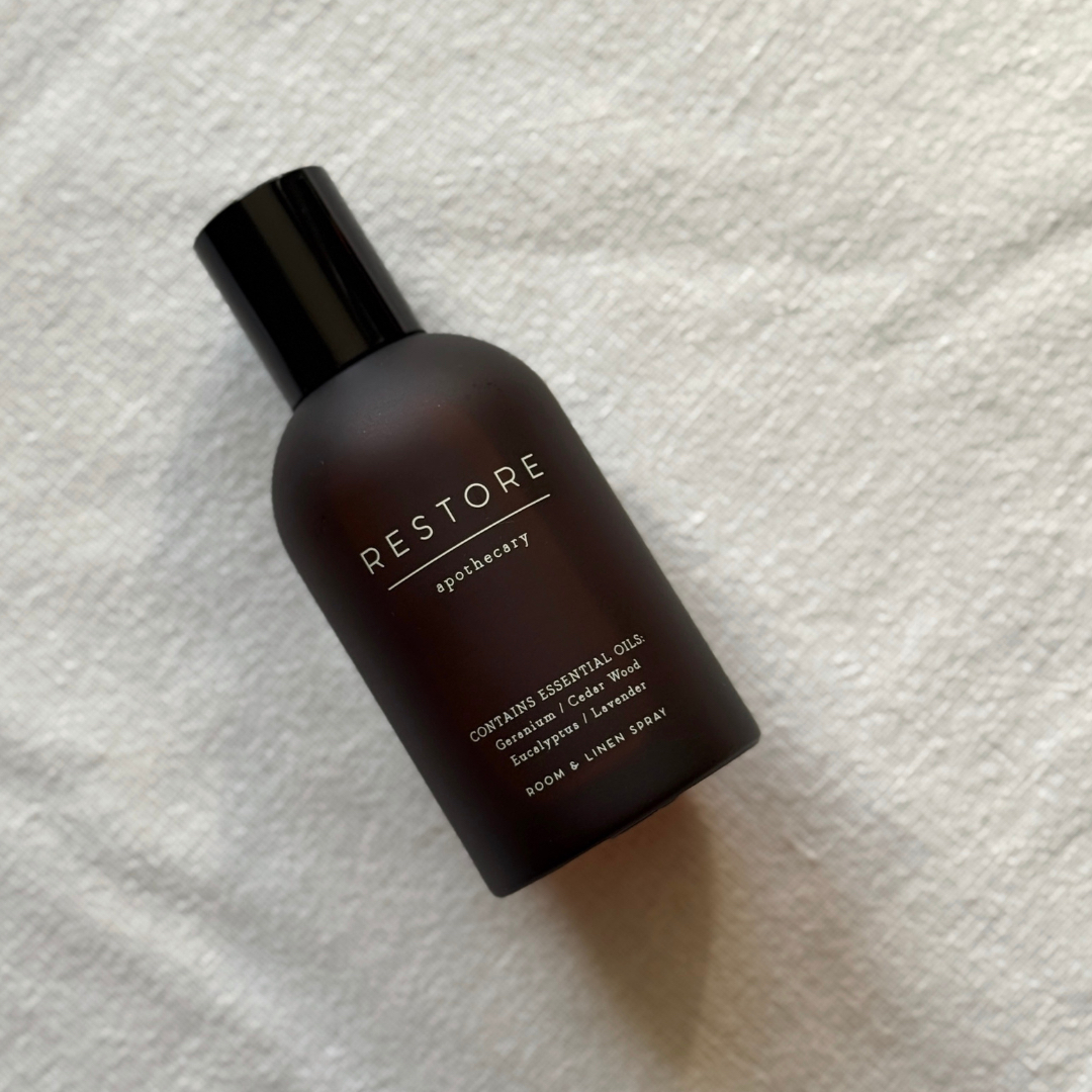 Bird's eye view of the M&S Apothecary Restore Room & Linen Spray against an off-white fabric background 
