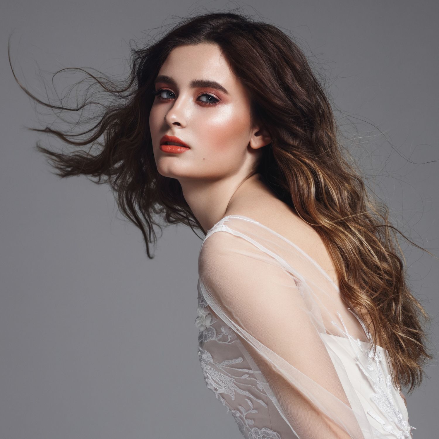 model wearing wedding dress, with wavy hair and make-up 